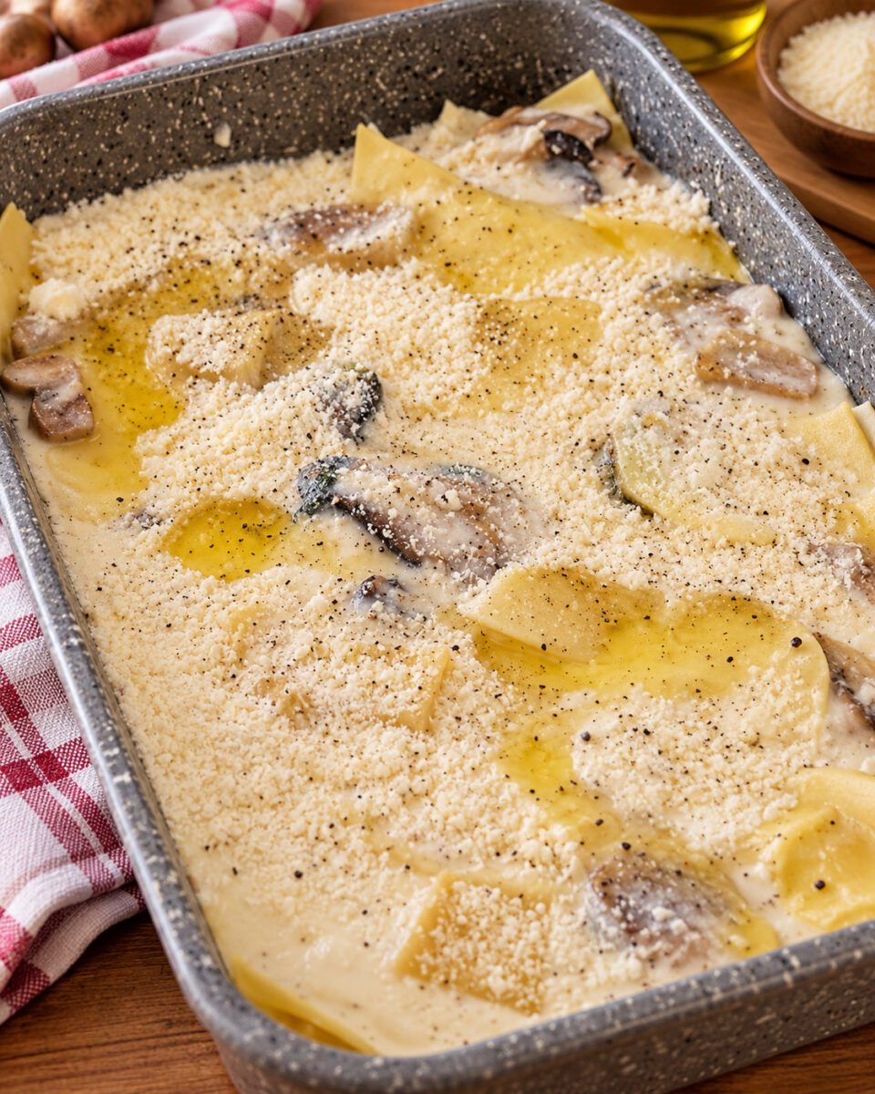 Teglia di lasagne ai funghi cardoncelli prima della cottura, con besciamella e Parmigiano
